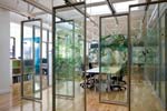 The skylit, multi-use conference room with sliding glass panels mounted with display boards in AECOM’s NYC office