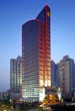 Outlined in lights at night, the St. Regis Shanghai cuts a slender profile against the skyline.