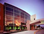 The curved glass curtainwall of the Genesis Heart Institute's lobby reflects the Midwest sunset.