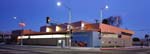 At dusk, Hyde Park Miriam Matthews Branch Library animates the Florence Avenue streetscape in South Los Angeles